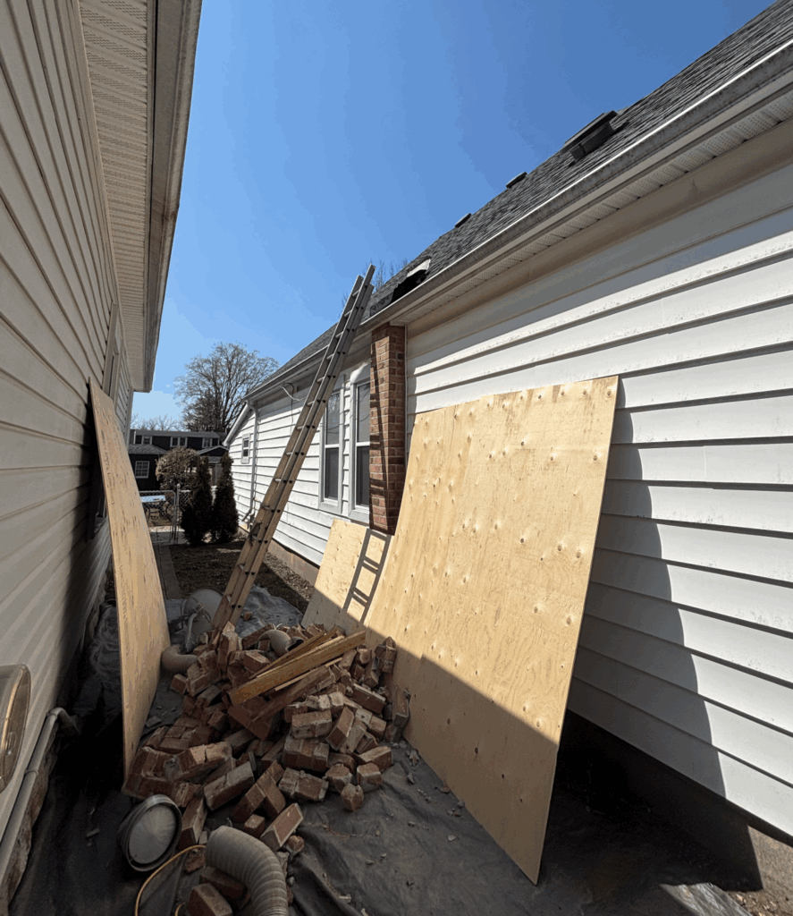 chimney being removed with bricks on the ground