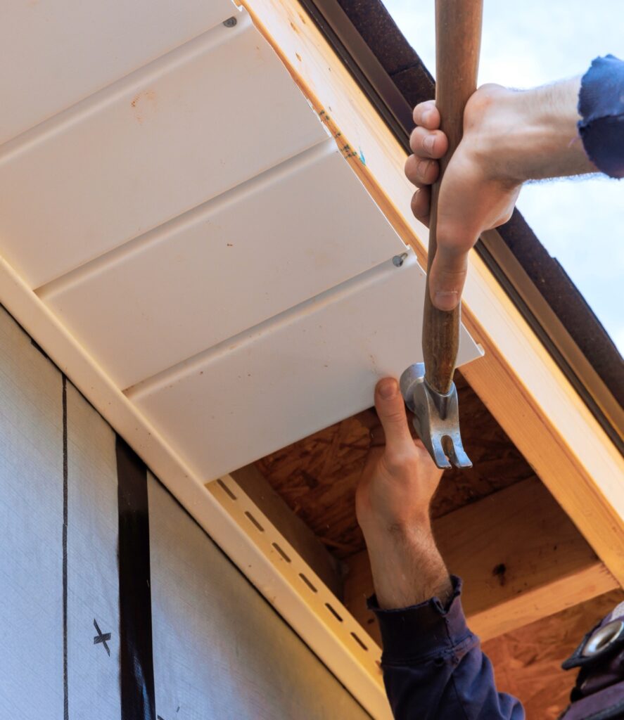 worker installing soffit on a house